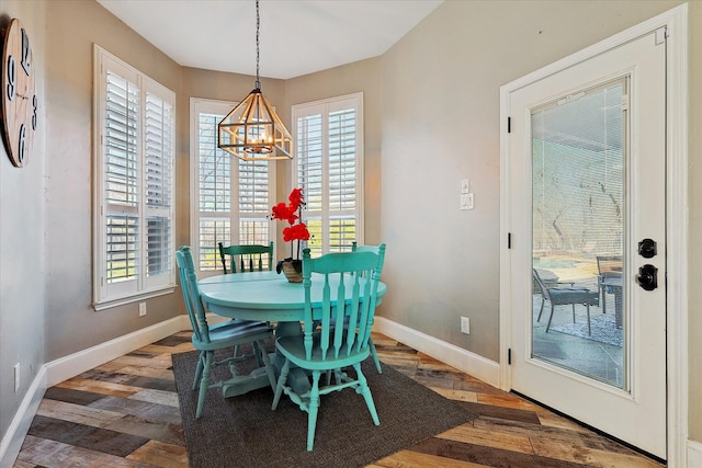 dining room with plenty of natural light, a chandelier, and dark wood-type flooring