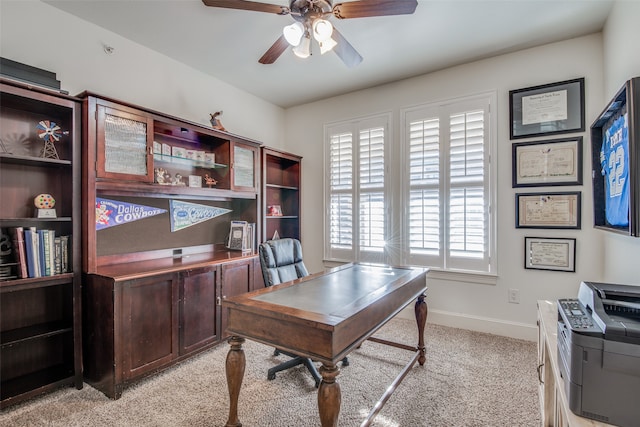 carpeted office space with ceiling fan