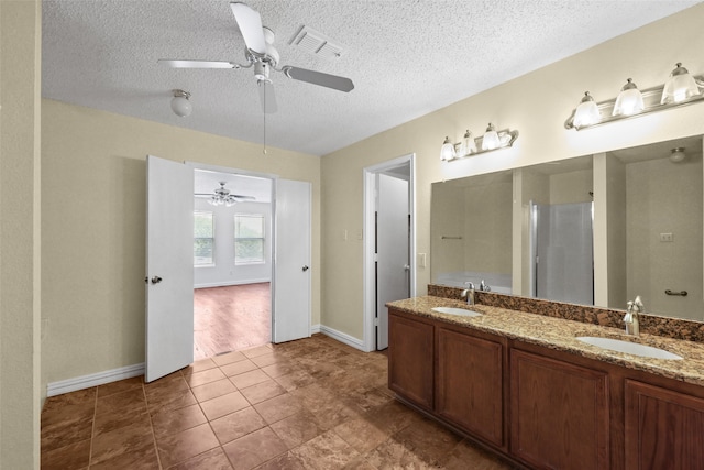 bathroom with tile patterned flooring, vanity, and a textured ceiling