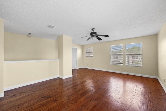 unfurnished room with a textured ceiling, dark wood-type flooring, and ceiling fan