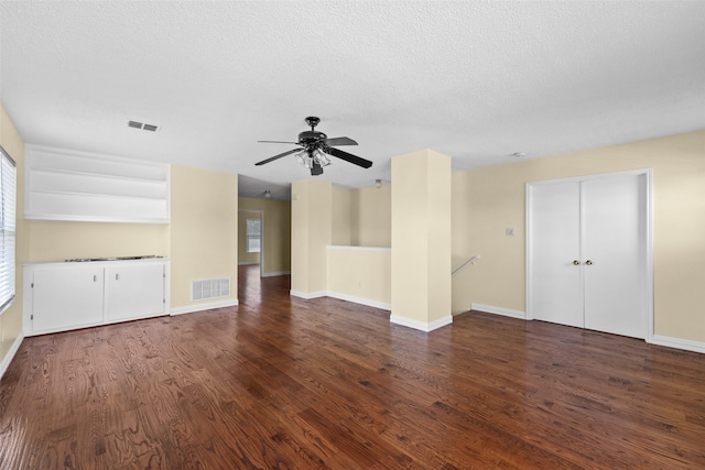 unfurnished living room with a textured ceiling, dark hardwood / wood-style floors, and ceiling fan