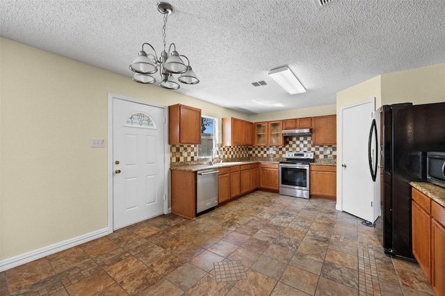 kitchen featuring tasteful backsplash, sink, a notable chandelier, hanging light fixtures, and appliances with stainless steel finishes