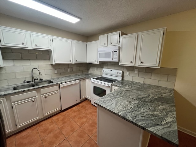 kitchen with white appliances, white cabinetry, sink, and tasteful backsplash