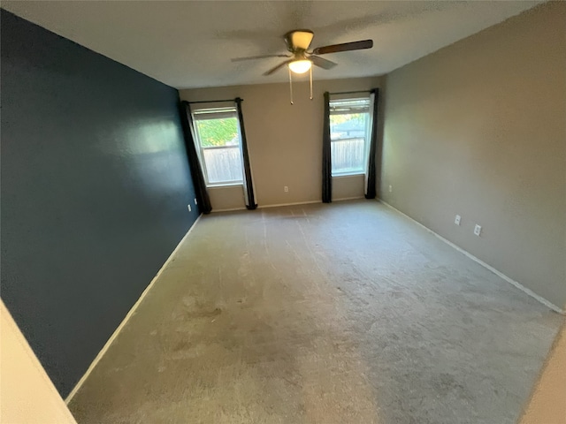 spare room with light carpet and ceiling fan