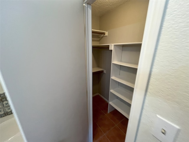 spacious closet with dark tile patterned flooring