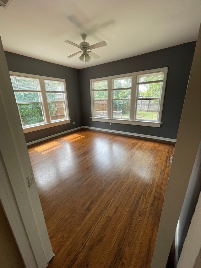 spare room with hardwood / wood-style floors, ceiling fan, and plenty of natural light