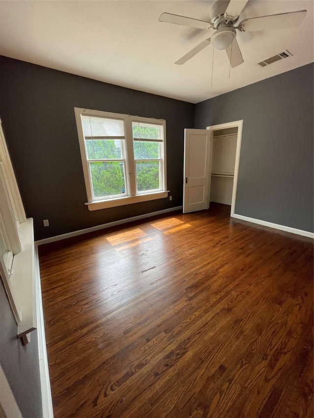 empty room featuring dark wood-type flooring and ceiling fan