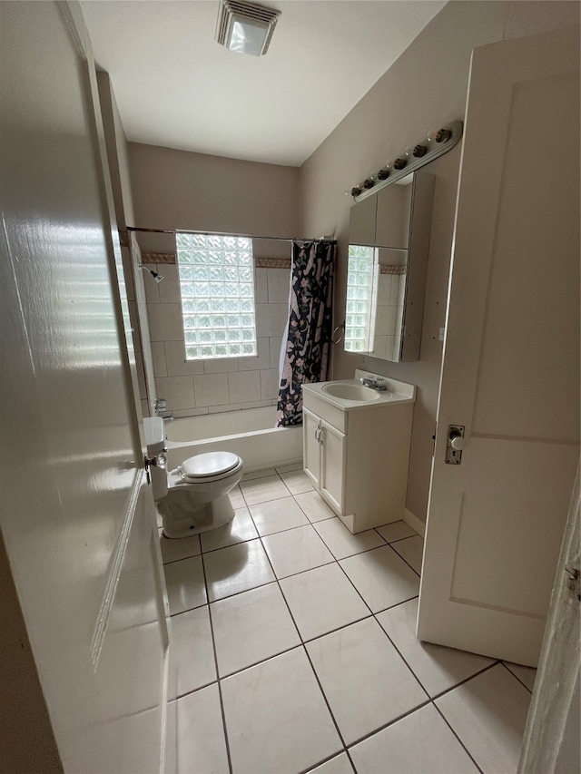 full bathroom featuring shower / bath combo with shower curtain, toilet, vanity, and tile patterned floors