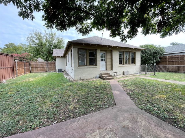 bungalow-style home with central air condition unit and a front yard