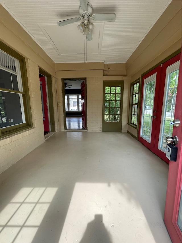 unfurnished sunroom featuring ceiling fan