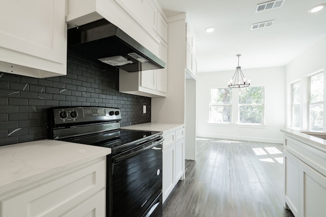 kitchen featuring white cabinets, a chandelier, and electric range