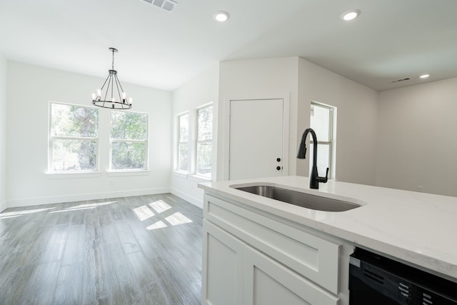 kitchen with dishwasher, light stone counters, sink, white cabinets, and light hardwood / wood-style floors