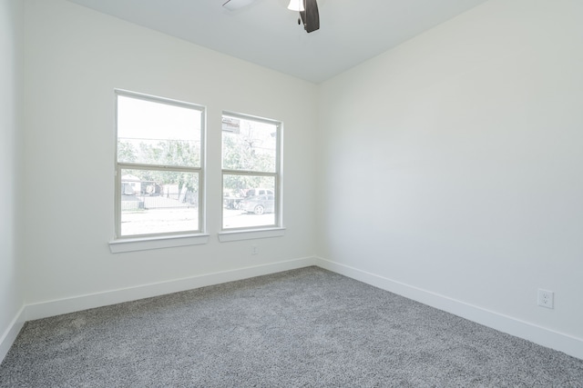 carpeted spare room featuring a healthy amount of sunlight and ceiling fan