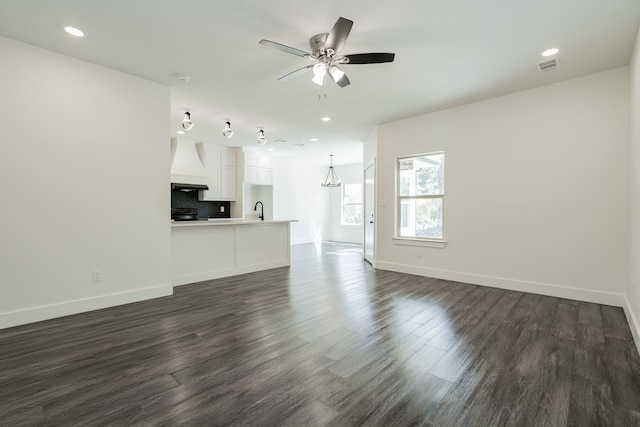 unfurnished living room with ceiling fan, dark hardwood / wood-style floors, and sink