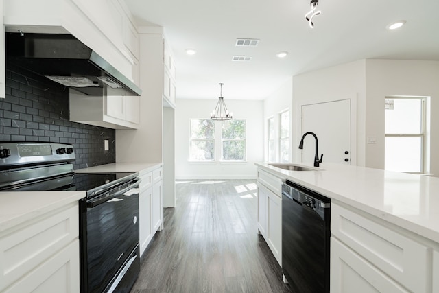 kitchen with black appliances, sink, hanging light fixtures, and white cabinets