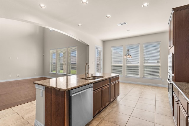 kitchen with light tile patterned floors, visible vents, stone counters, a sink, and stainless steel appliances