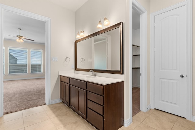 bathroom featuring tile patterned flooring, baseboards, vanity, and a ceiling fan