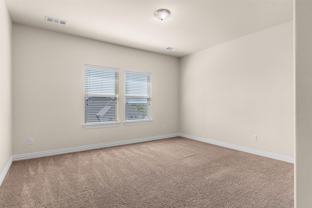 carpeted empty room with visible vents and baseboards