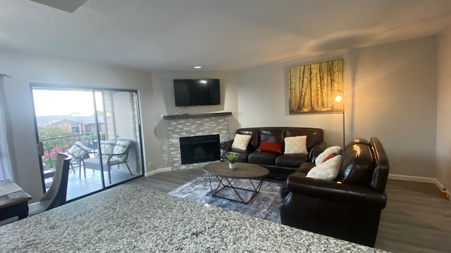 living room with a tiled fireplace and dark hardwood / wood-style floors