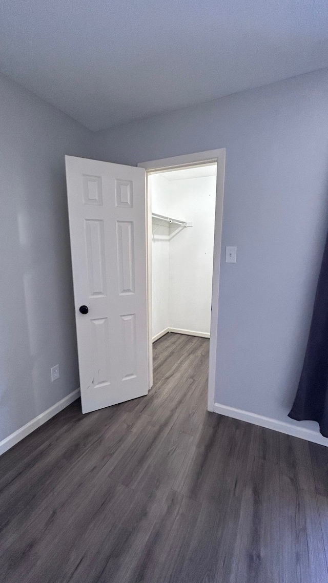 unfurnished bedroom with a closet and dark hardwood / wood-style flooring