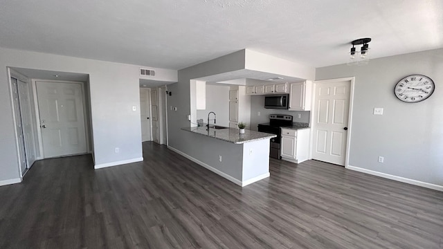 kitchen with white cabinetry, kitchen peninsula, sink, dark hardwood / wood-style floors, and appliances with stainless steel finishes