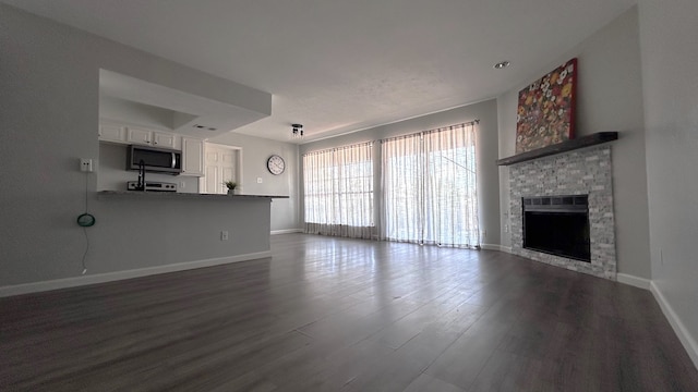 unfurnished living room with a fireplace and dark hardwood / wood-style floors