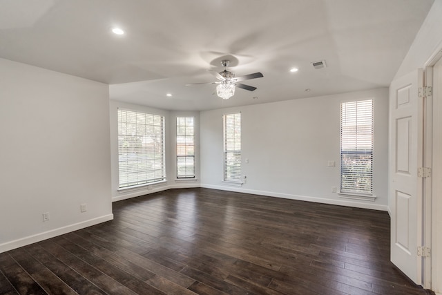 spare room featuring ceiling fan, dark hardwood / wood-style floors, and a healthy amount of sunlight