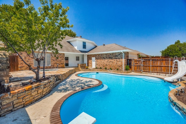 view of swimming pool with a water slide and a patio