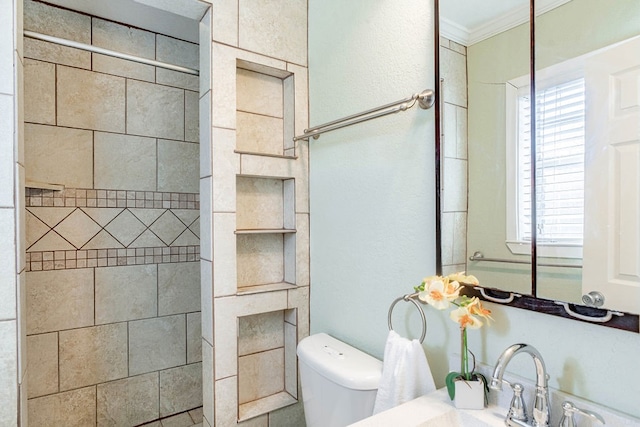 bathroom featuring ornamental molding, toilet, and a healthy amount of sunlight