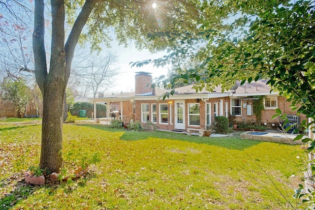 rear view of property featuring a yard