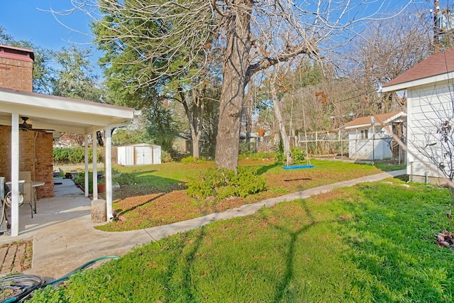 view of yard with ceiling fan, a storage unit, and a patio