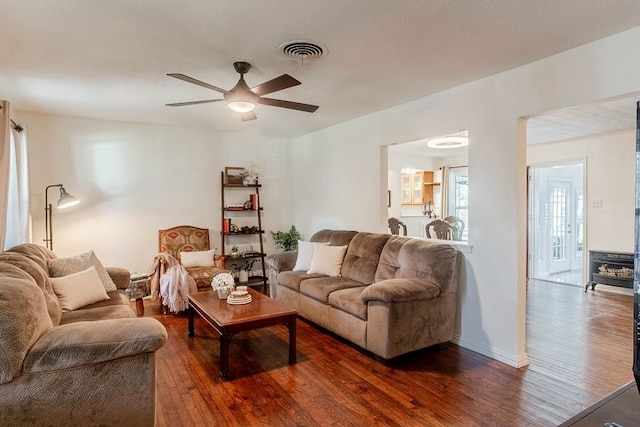 living room with ceiling fan and dark hardwood / wood-style flooring