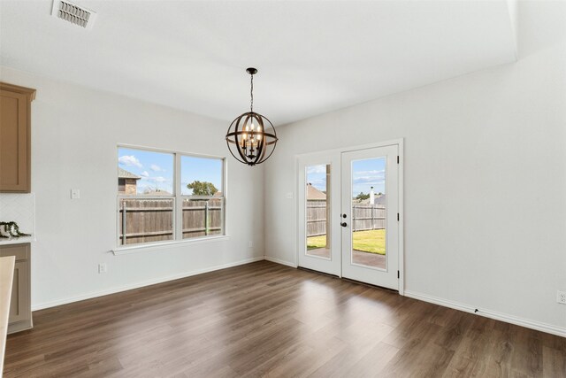 unfurnished dining area with dark hardwood / wood-style flooring and a chandelier