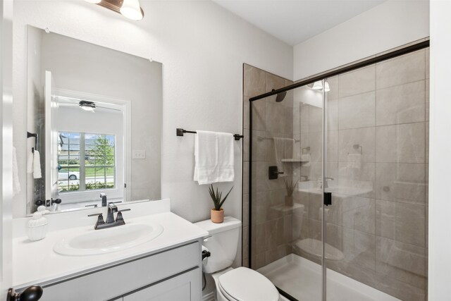 bathroom featuring vanity, toilet, and an enclosed shower