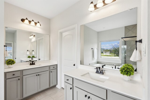 bathroom featuring tile patterned floors, an enclosed shower, and vanity