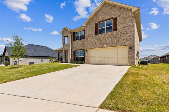 view of front of house with cooling unit, a garage, and a front yard