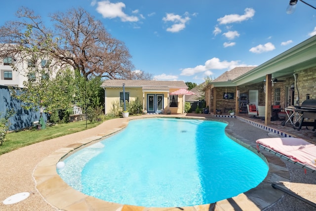 view of pool with a patio, area for grilling, and ceiling fan