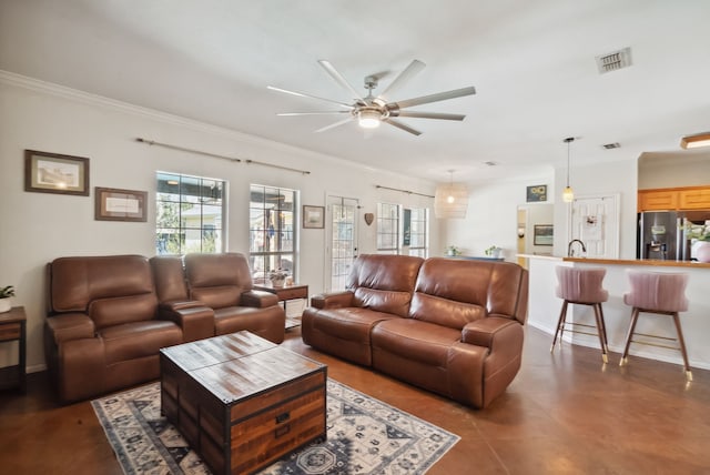 living room with crown molding and ceiling fan