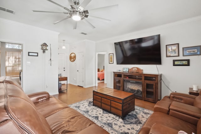 living room featuring ceiling fan and crown molding