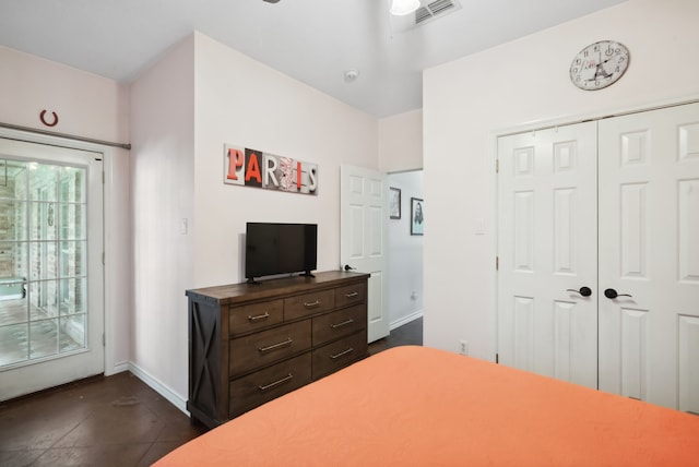 bedroom featuring access to exterior, dark tile patterned floors, and a closet