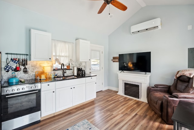 kitchen with white cabinetry, sink, ceiling fan, a wall mounted air conditioner, and hardwood / wood-style flooring