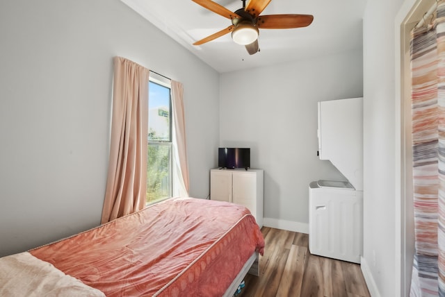 bedroom with multiple windows, ceiling fan, and wood-type flooring