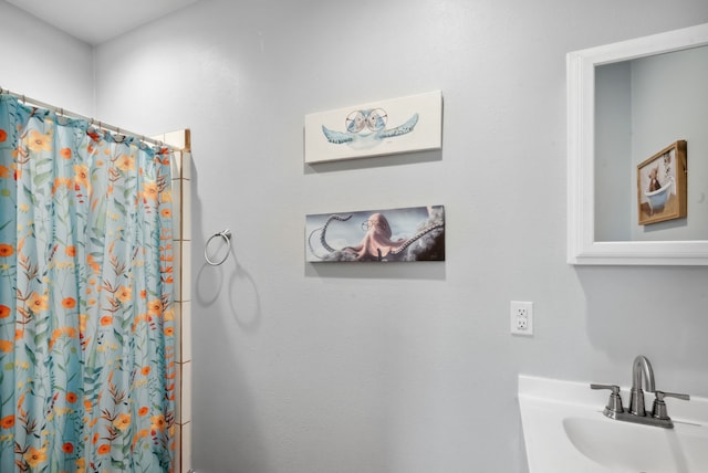 bathroom with a shower with shower curtain and sink