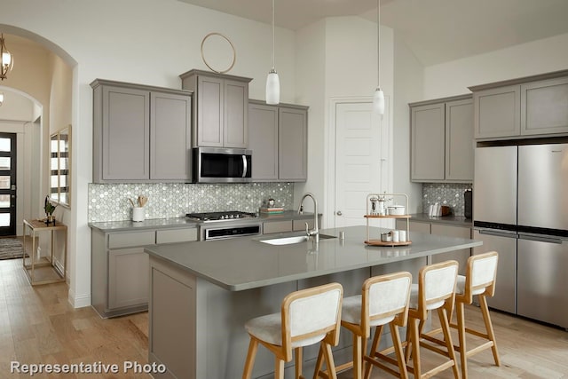 kitchen with light hardwood / wood-style flooring, stainless steel appliances, and gray cabinetry