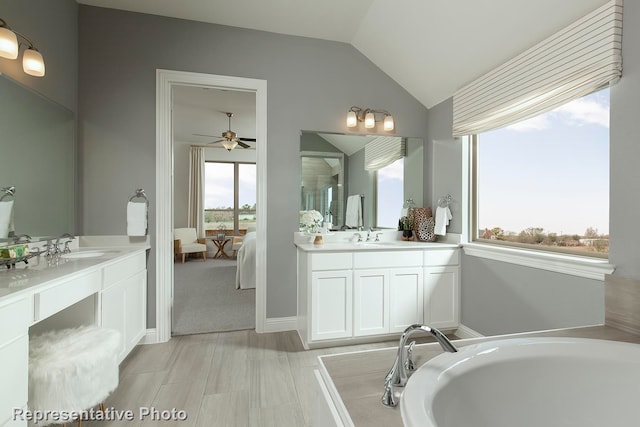 bathroom featuring vanity, a bath, ceiling fan, and lofted ceiling