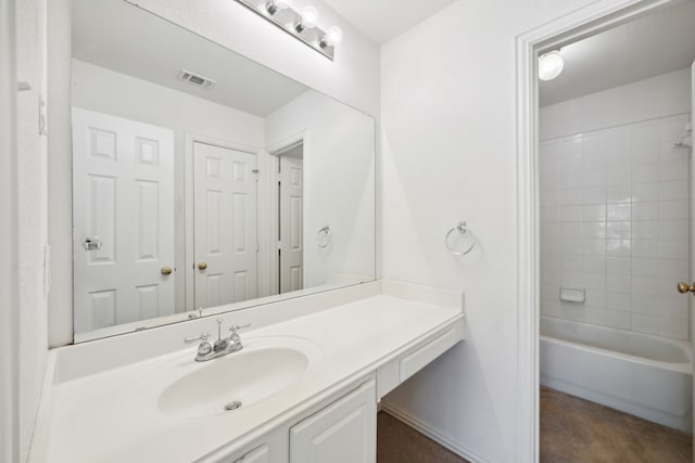 bathroom featuring tiled shower / bath combo and vanity