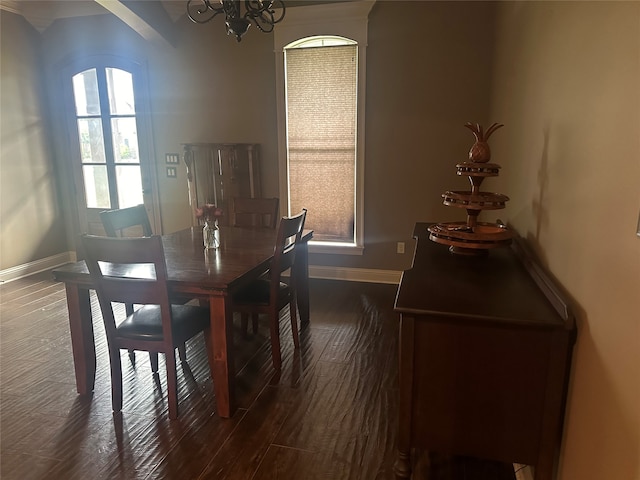 dining room with dark wood-type flooring and a notable chandelier