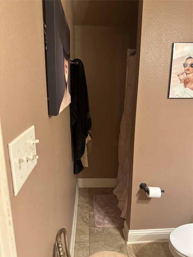 bathroom with toilet and tile patterned floors