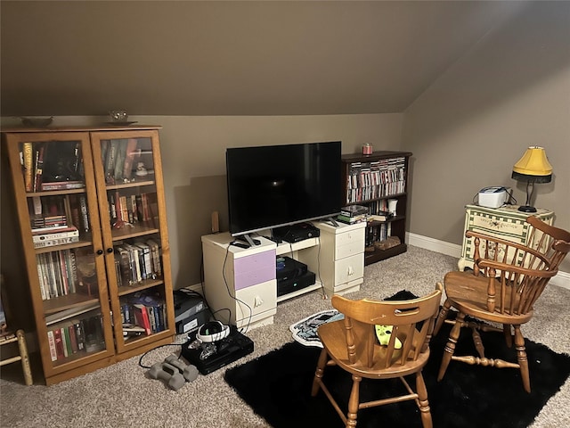 sitting room featuring carpet floors and vaulted ceiling