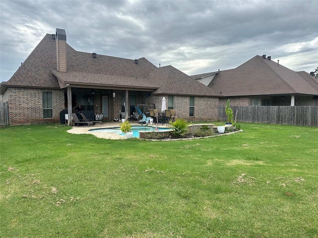 rear view of house with a patio area and a lawn